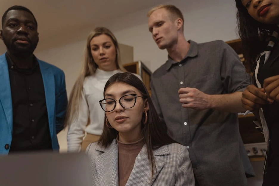 Team diversificato e collaborativo durante una riunione in un ufficio luminoso.